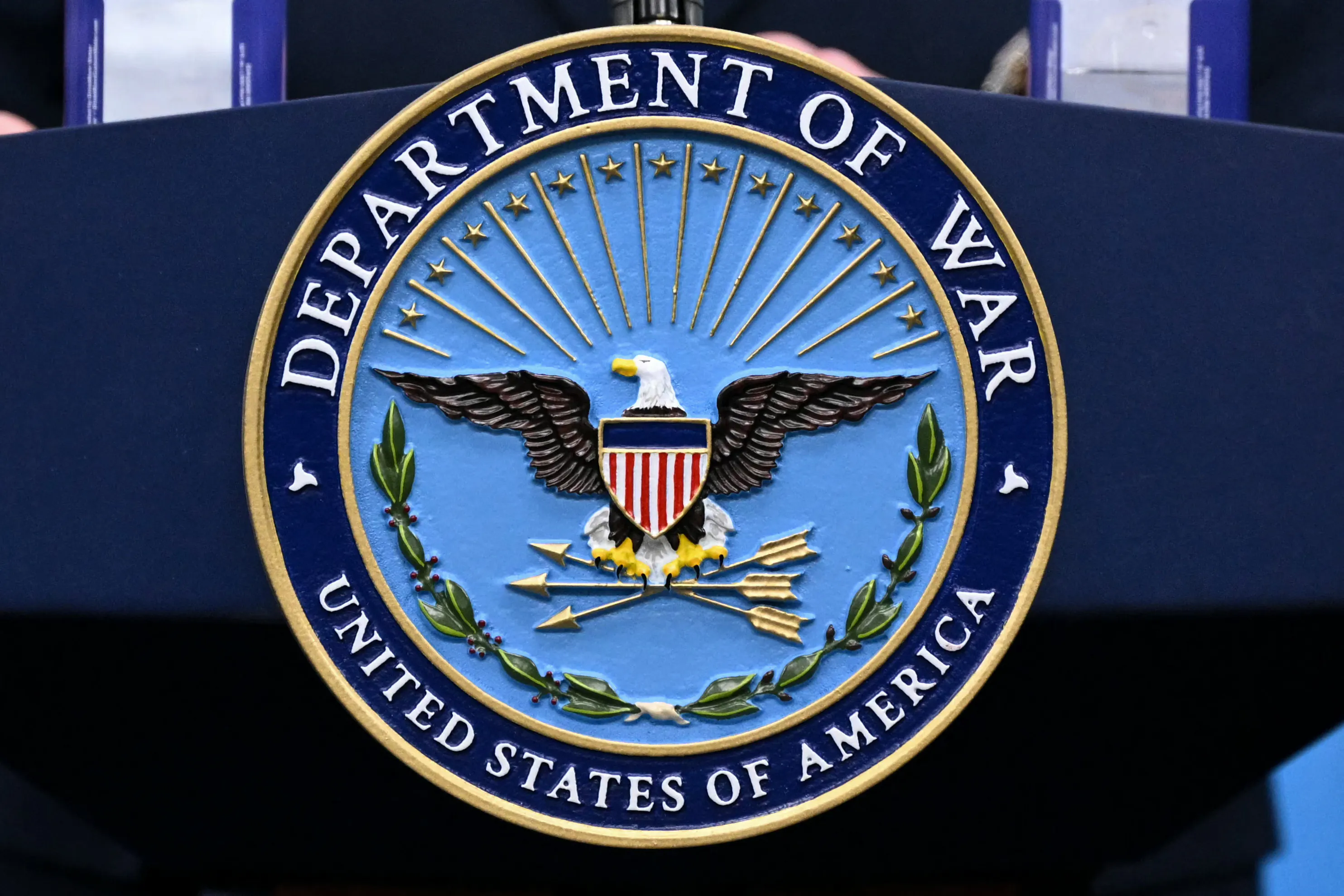 A "Department of War" seal on a podium