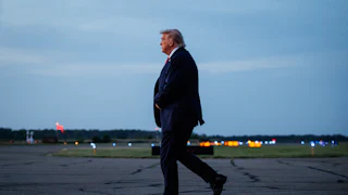 Donald Trump walks on an airport tarmac