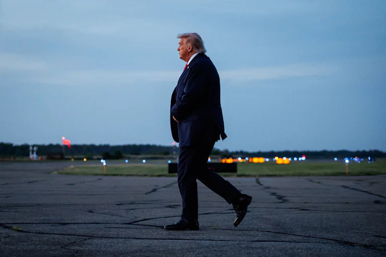 Donald Trump walks on an airport tarmac