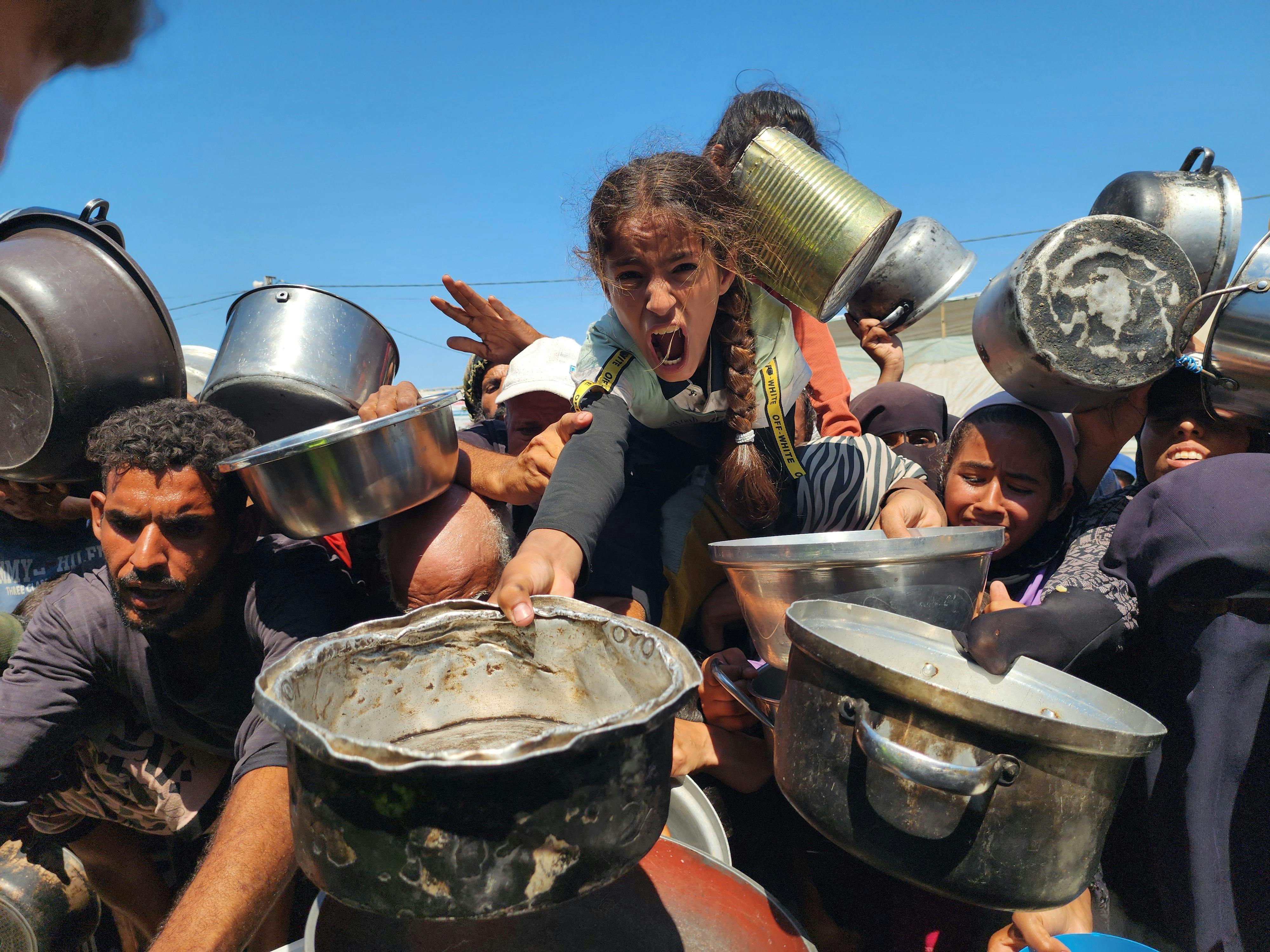 Palestinians struggling with hunger crowd around as a charity distributes food in the Al-Mawasi area of Khan Yunis, Gaza amid ongoing Israeli restrictions blocking humanitarian aid from reaching Gaza, on July 24, 2025. 