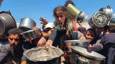 Palestinians struggling with hunger crowd around as a charity distributes food in the Al-Mawasi area of Khan Yunis, Gaza amid ongoing Israeli restrictions blocking humanitarian aid from reaching Gaza, on July 24, 2025.