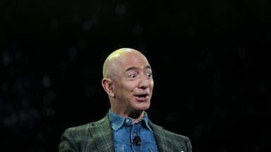 Jeff Bezos, against a black backdrop, looks surprised and excited
