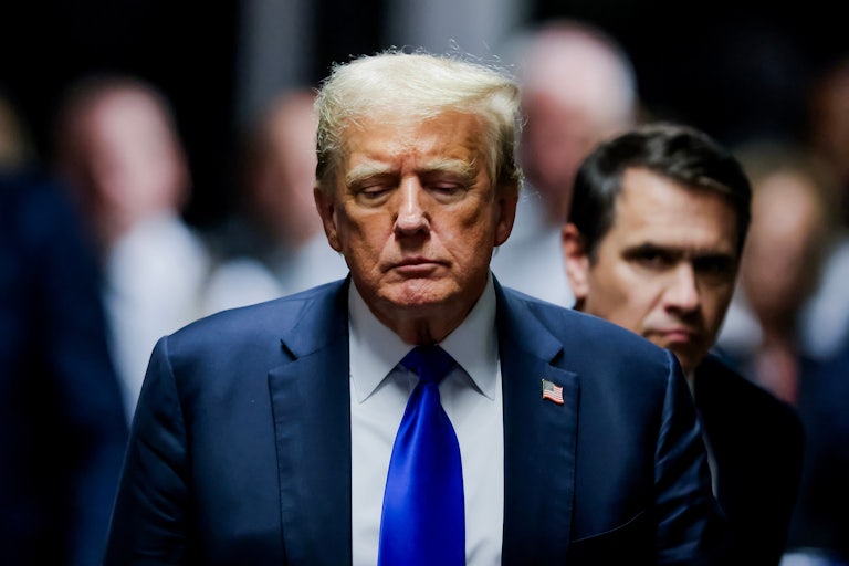 Donald Trump looks down as his lawyer Todd Blanche walks behind him at his hush-money trial