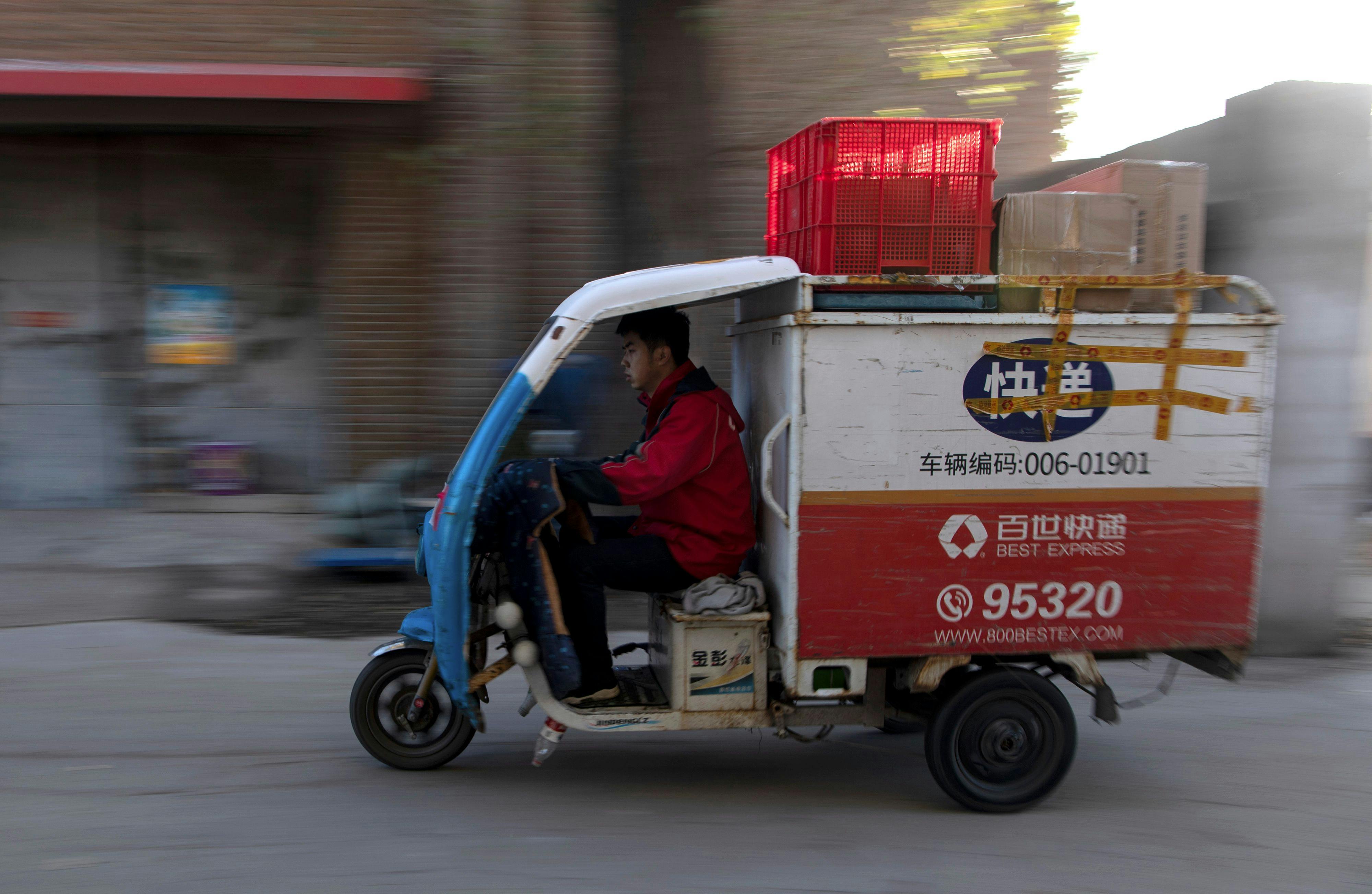 A worker drives a tricycle to deliver packages in Beijing, November, 2019