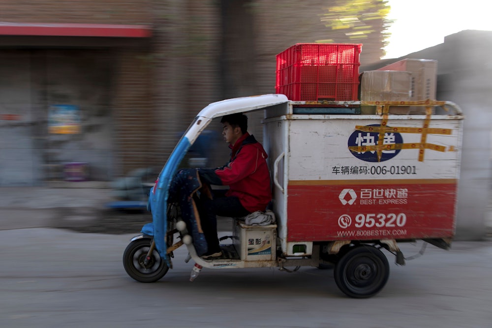 A worker drives a tricycle to deliver packages in Beijing, November, 2019