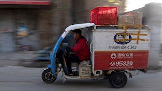A worker drives a tricycle to deliver packages in Beijing, November, 2019