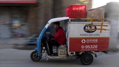 A worker drives a tricycle to deliver packages in Beijing, November, 2019