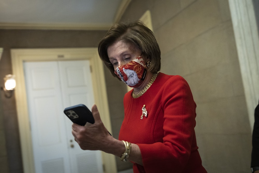 Democratic House Speaker Nancy Pelosi looks at her phone as she returns to her office on Capitol Hill.