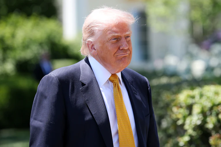 President Donald Trump grins outside the White House