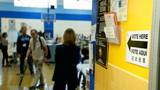 "Vote Here” signage and voters at a polling location
