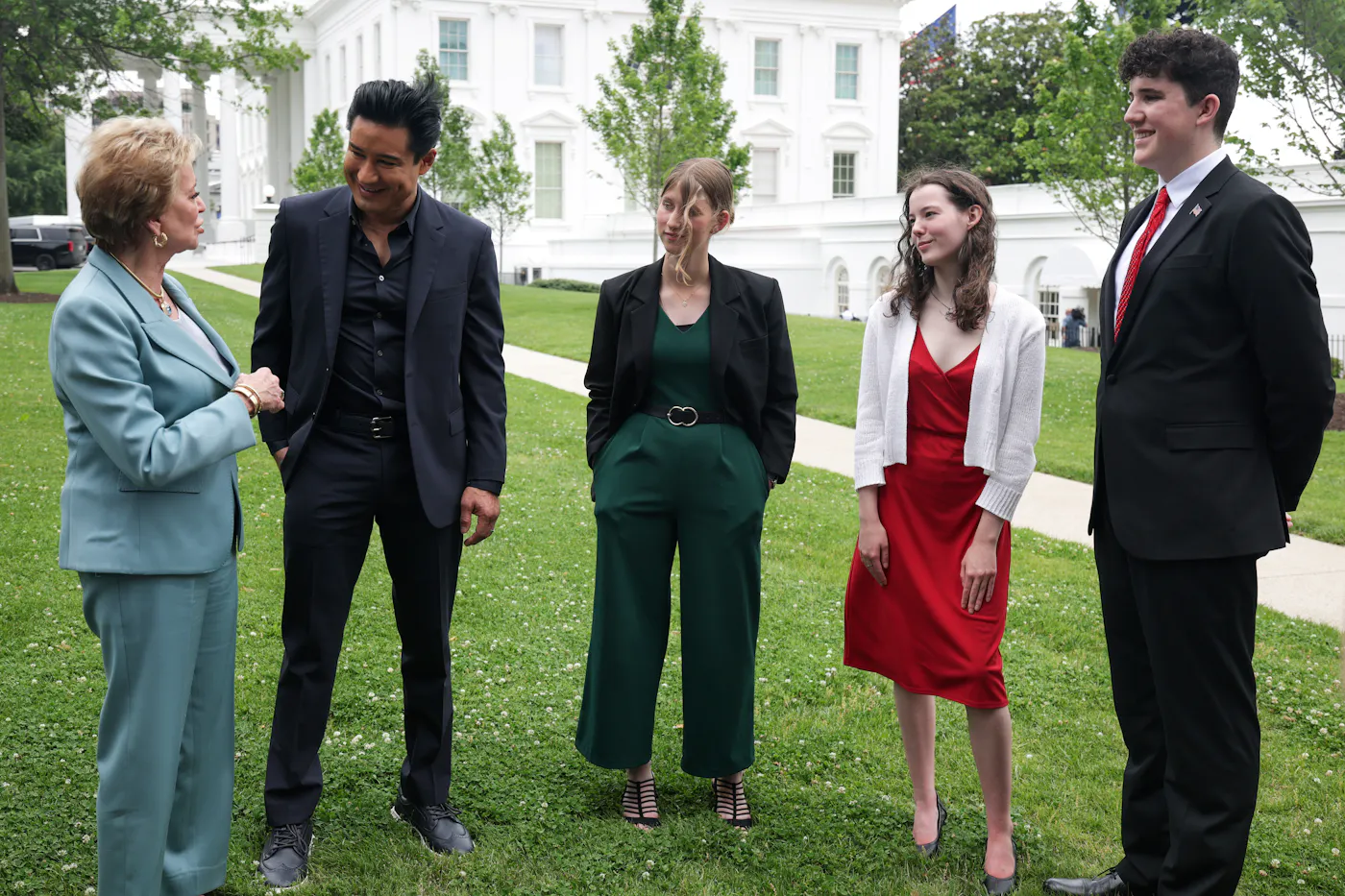 Secretary of Education Linda McMahon and Access Hollywood host Mario Lopez speak as the three white finalists of the Presidential 1776 Award listen to them outside the White House.
