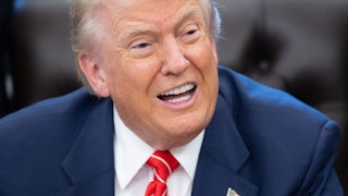Donald Trump speaks while sitting at his desk in the Oval Office