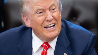 Donald Trump speaks while sitting at his desk in the Oval Office