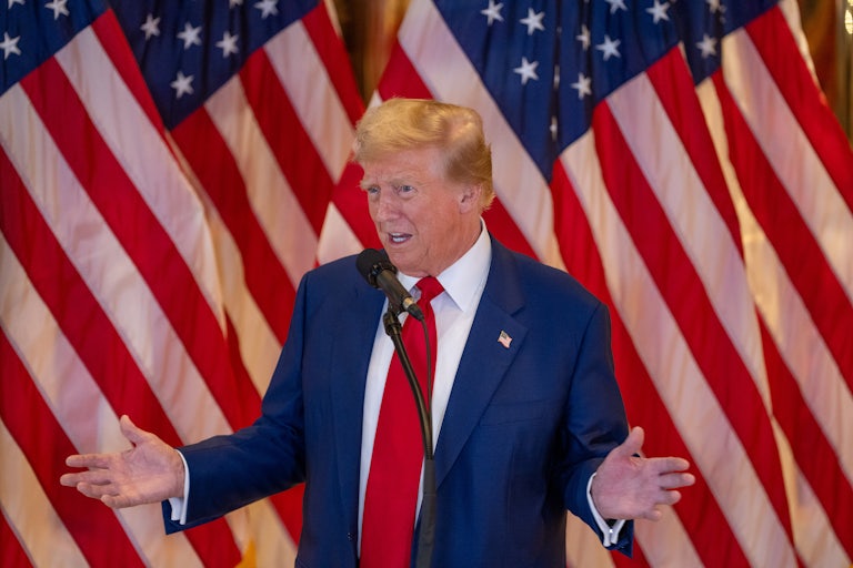 Donald Trump gestures as he speaks into a microphone