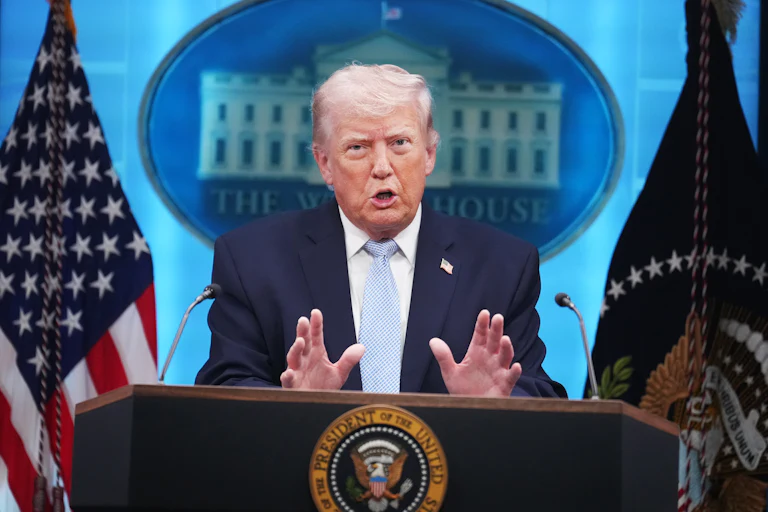Donald Trump gestures while speaking at a podium