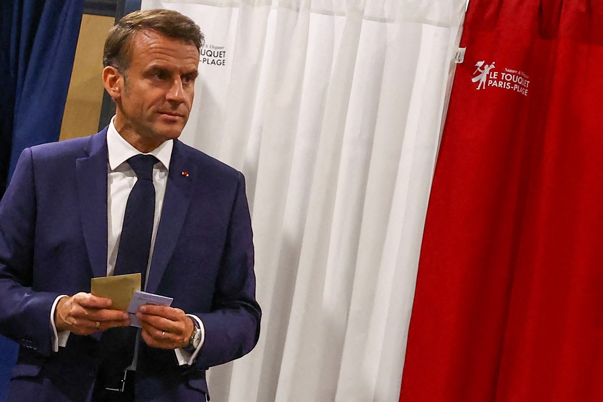 Macron holds papers in his hands.