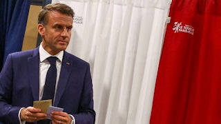 Macron holds papers in his hands.