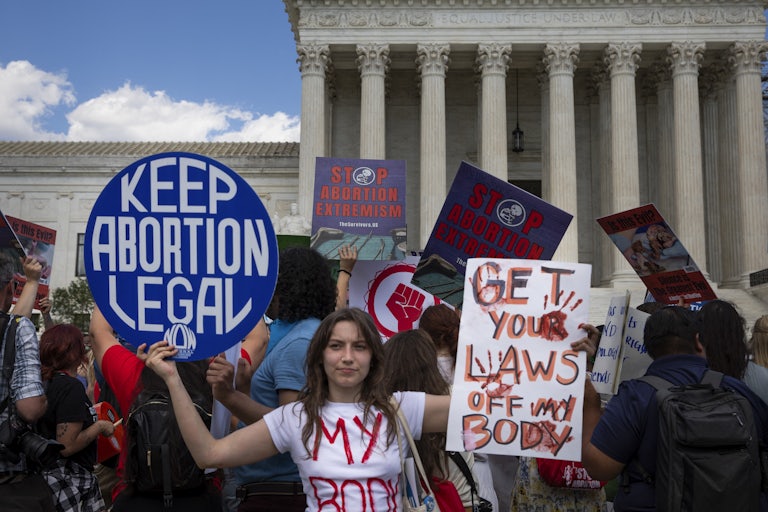 People hold up pro-abortion rights signs outside the Supreme Court