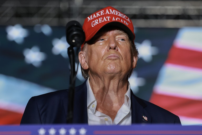 Donald Trump purses his lips and lifts his head. He is very, very sweaty