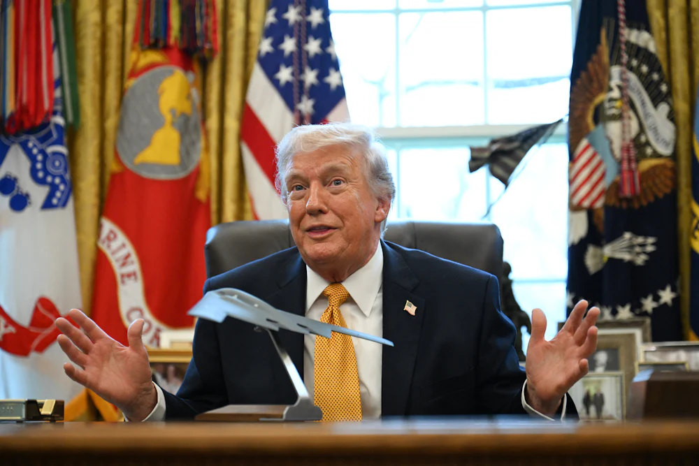 Trump in the Oval Office with a model of a stealth bomber on the Resolute Desk