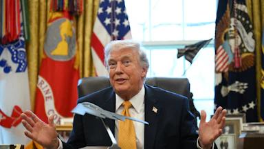Trump in the Oval Office with a model of a stealth bomber on the Resolute Desk