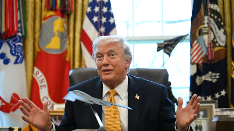 Trump in the Oval Office with a model of a stealth bomber on the Resolute Desk