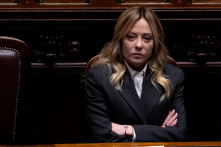 Italian Prime Minister Giorgia Meloni crosses her arms