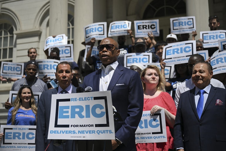 New York City Mayor Eric Adams stands with supporters.