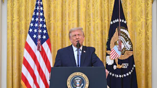 Donald Trump at the podium next to the U.S. flag