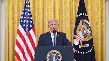 Donald Trump at the podium next to the U.S. flag