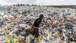 A man wades through a landfill in Bulawayo, Zimbabwe.