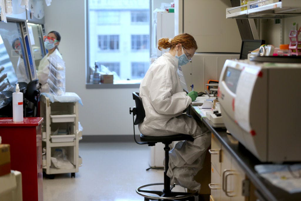 Two masked female science researchers assess results in a lab in Washington