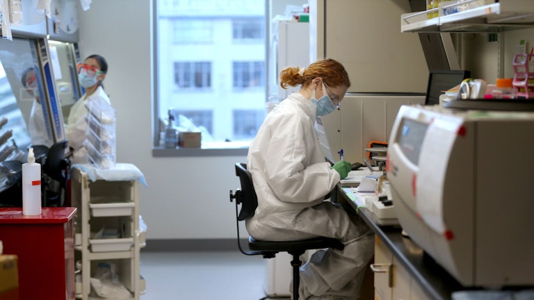 Two masked female science researchers assess results in a lab in Washington