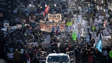 This image shows masses of protesters holding signs protesting ICE.