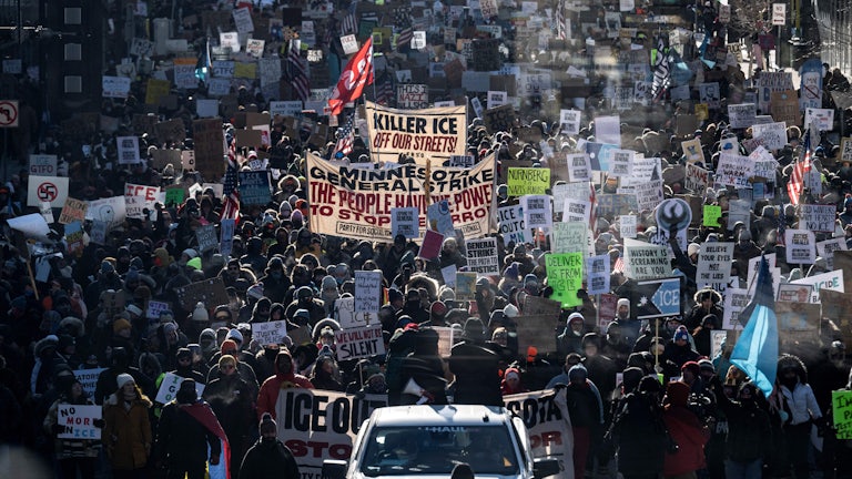 This image shows masses of protesters holding signs protesting ICE.