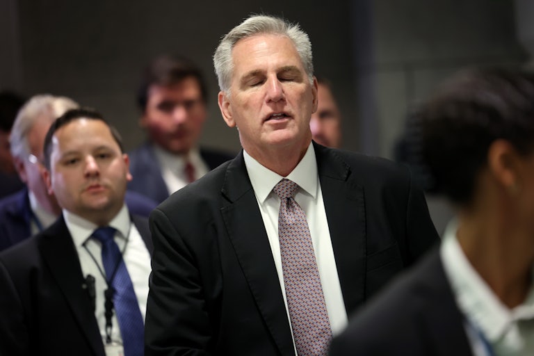 House Speaker Kevin McCarthy grimaces as he walks to another meeting with the House Republican caucus.