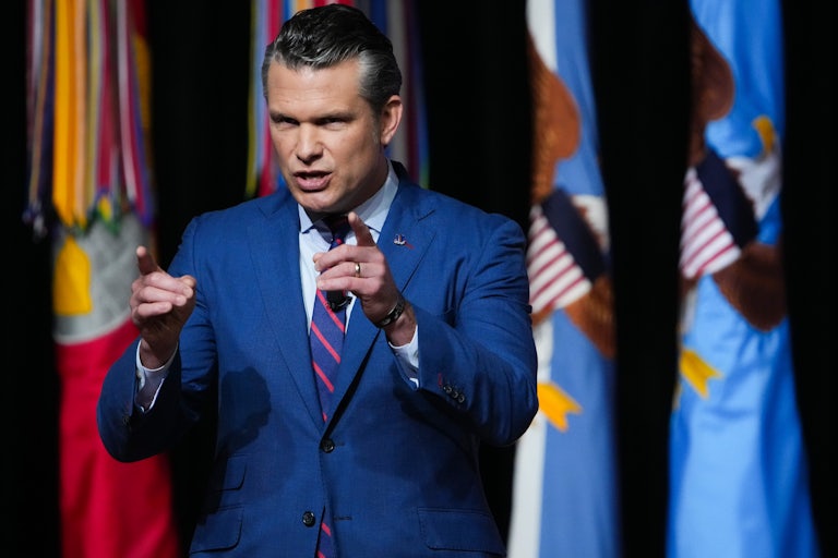 Defense Secretary Pete Hegseth points both fingers while he speaks at the military meeting.