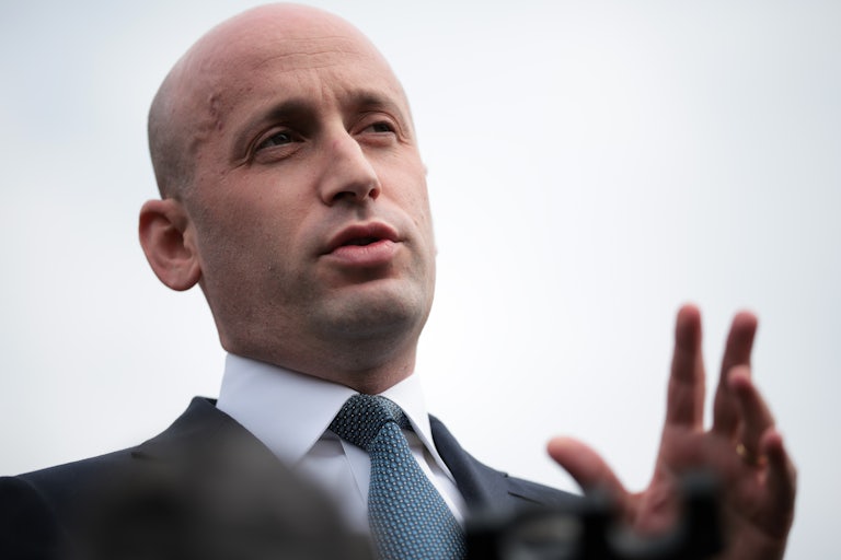 Stephen Miller, looking very bald, speaks to reporters