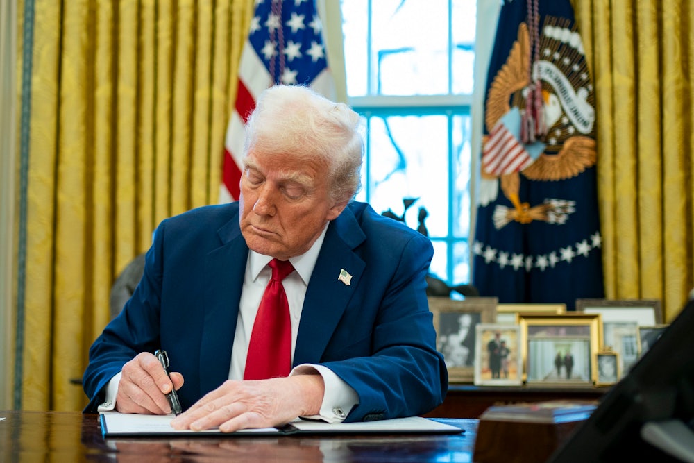 Donald Trump signs an executive order in the Oval Office of the White House.