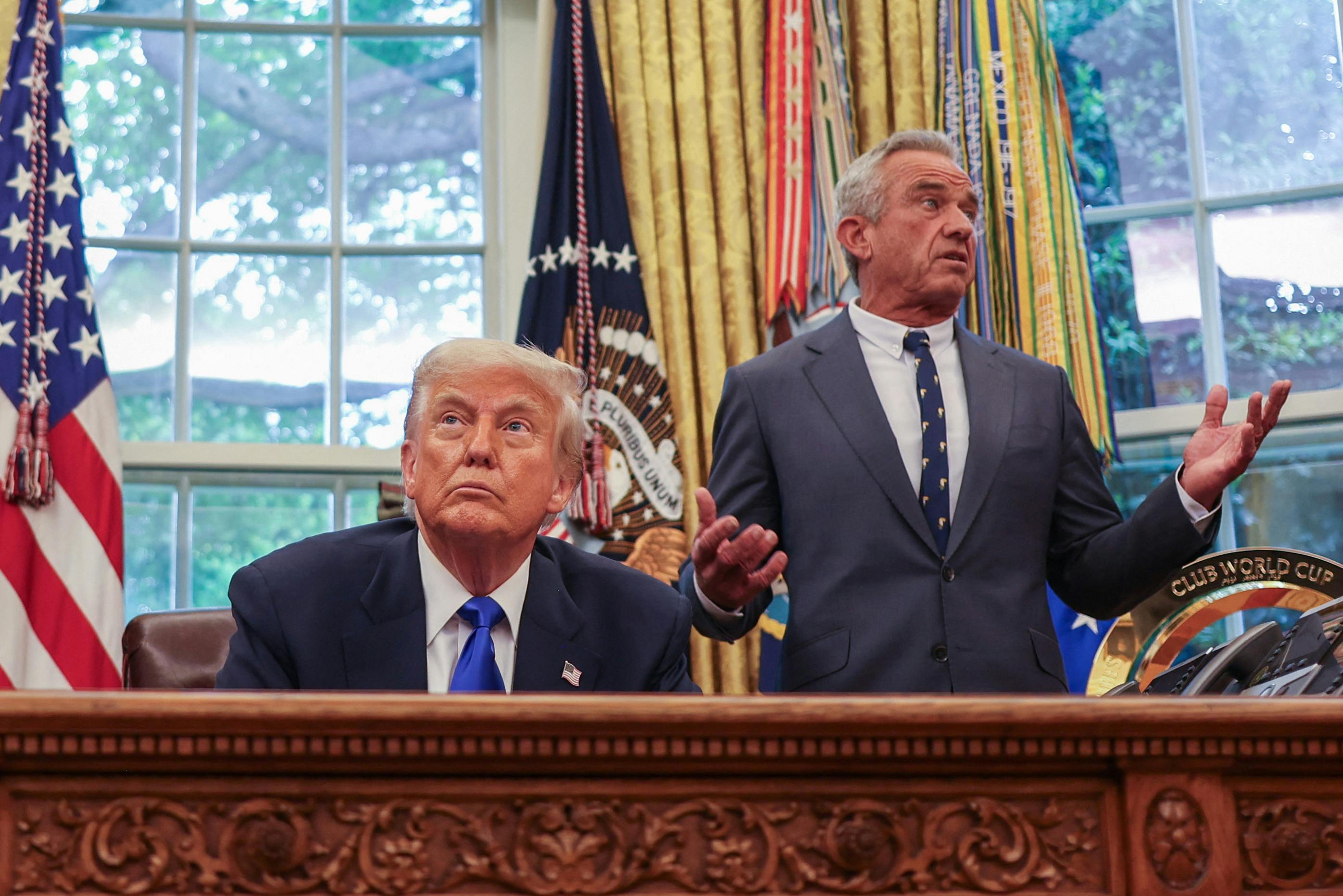 Secretary of Health and Human Services Robert F. Kennedy Jr. speaks to President Donald Trump during an executive orders signing event in the Oval Office.