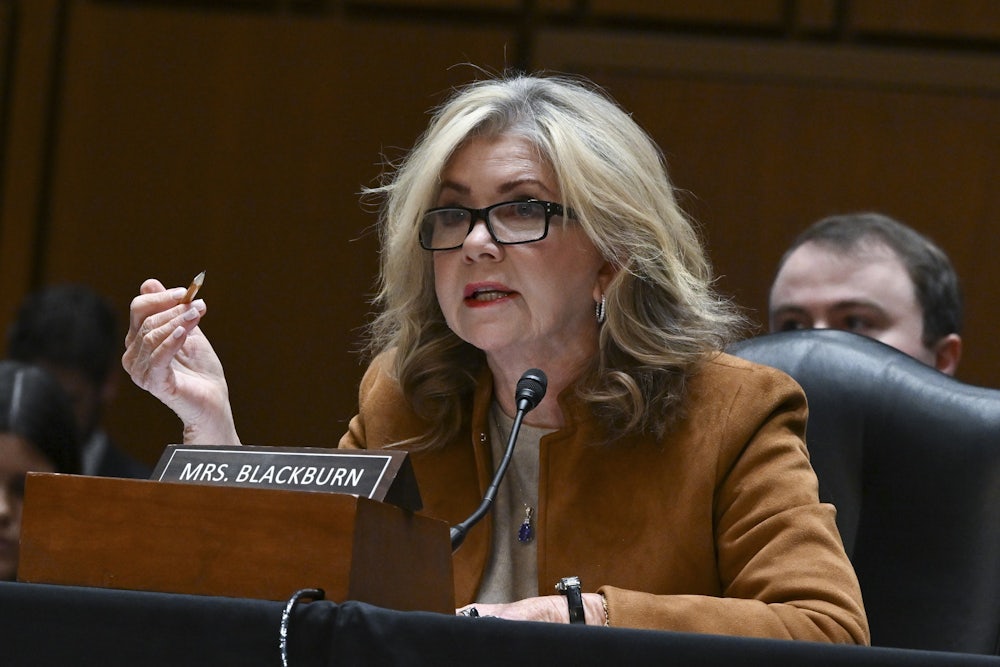 Marsha Blackburn gesticulates while speaking while seated.