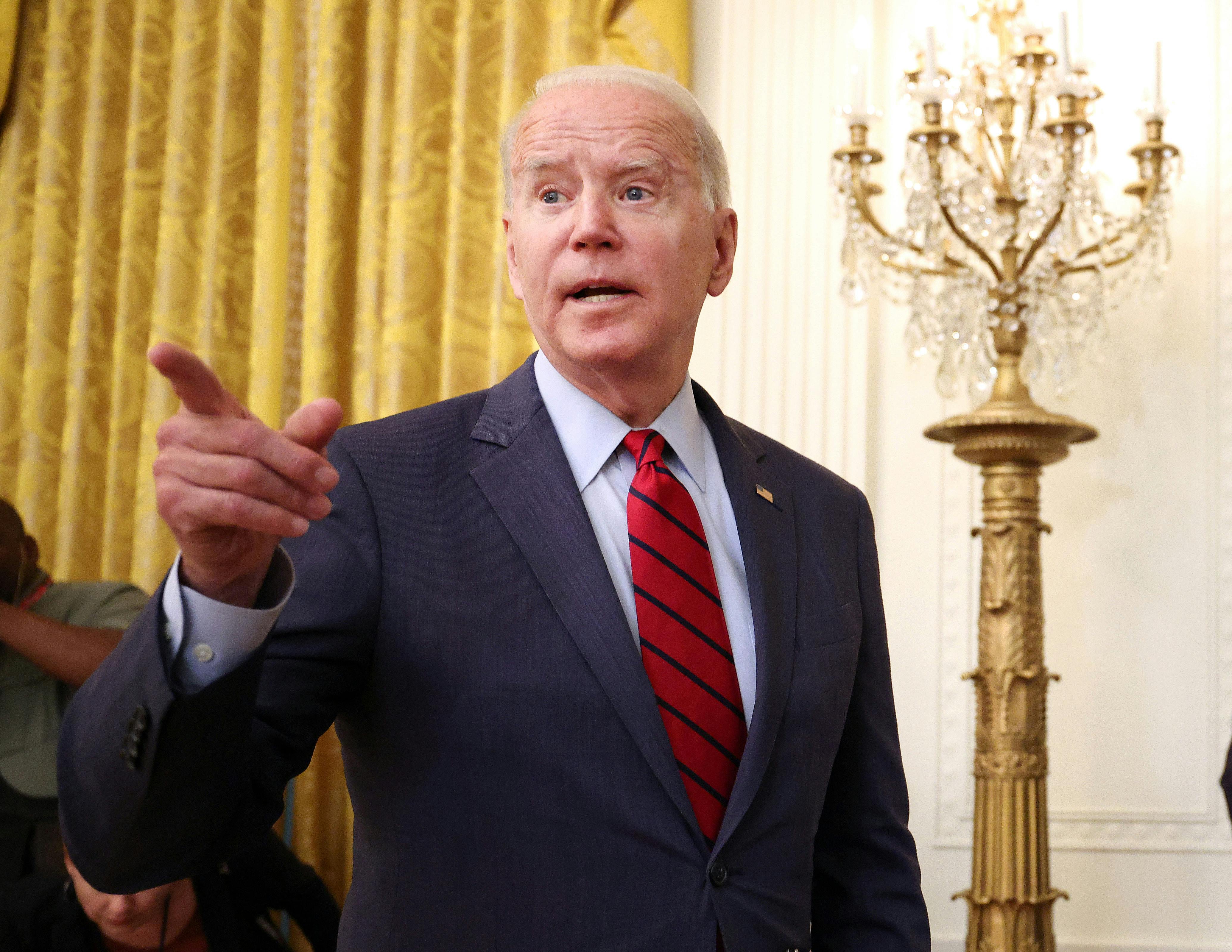 President Joe Biden points to the crowd as he departs a press conference.