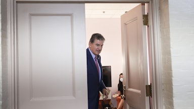 West Virginia Senator Joe Manchin stands in a doorwar as he leaves a meeting.