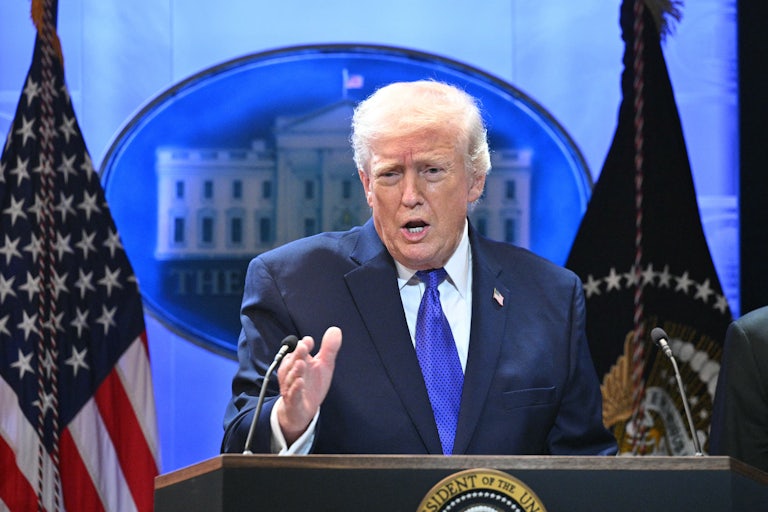 Donald Trump gestures and speaks at a podium