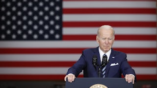 Joe Biden stands behind a lectern in front of the U.S. flag.