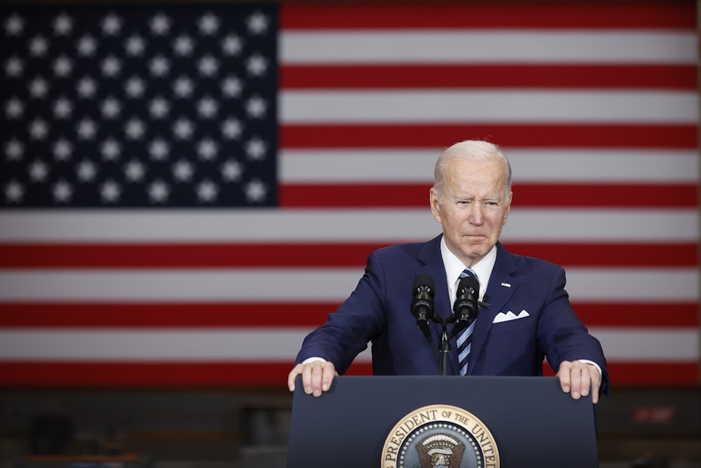 Joe Biden stands behind a lectern in front of the U.S. flag.