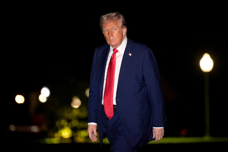Donald Trump walks outside the White House