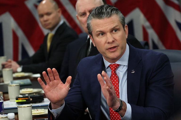 Defense Secretary Pete Hegseth speaks animatedly with his hands in a meeting.