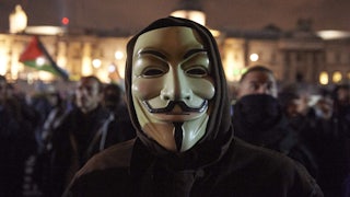 Man wearing a Guy Fawkes mask in the street at nighttime at the “Million Masks March,” organized by the group Anonymous, in London on November 5, 2017