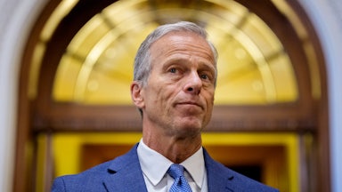 John Thune looks out in front of a doorway